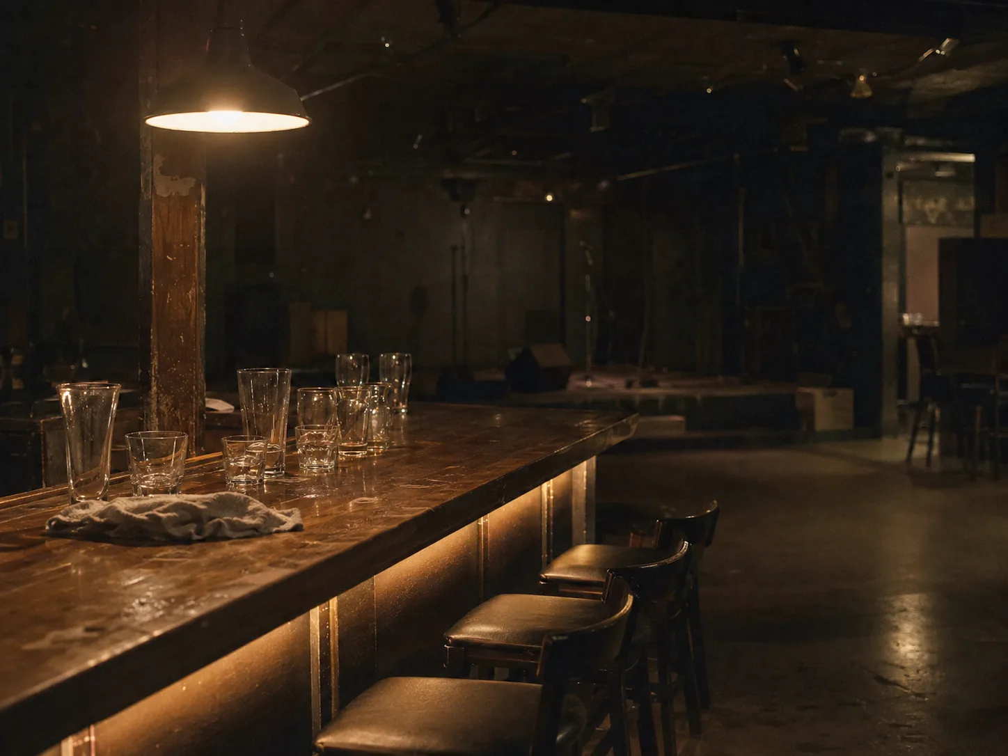 A bar counter after last call, glasses gathered, the room emptied