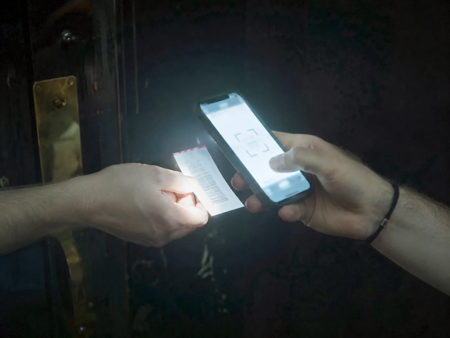 A ticket being scanned at the door, hands only